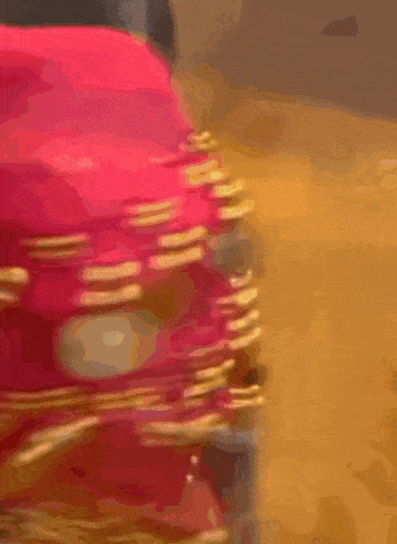 a blurred image of a red object with gold chains