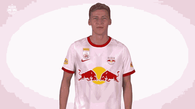 a man wearing a red bull jersey is making a face