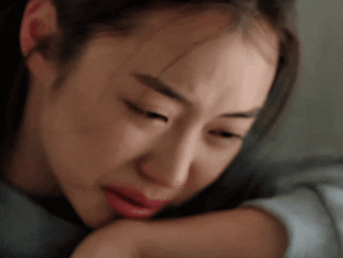 a woman is crying with her eyes closed