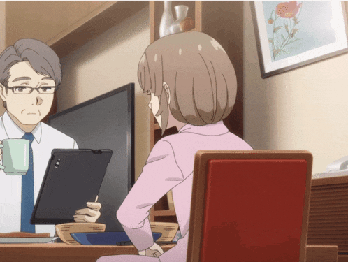 a man and a woman sit at a table with a tablet