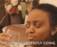 a woman is sitting on a couch holding a glass of wine and says `` my day is currently going '' .