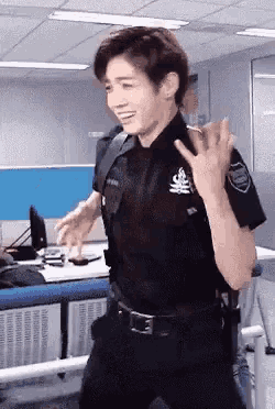 a man in a police uniform is standing in a room .