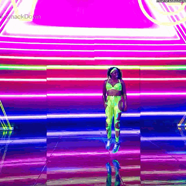 a woman in a neon outfit is standing in front of a colorful background that says ' smackdown '