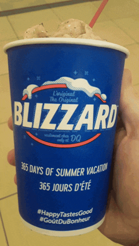 a person holding a blizzard cup with ice cream in it
