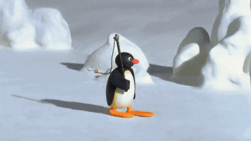 a penguin is walking in the snow holding a rope