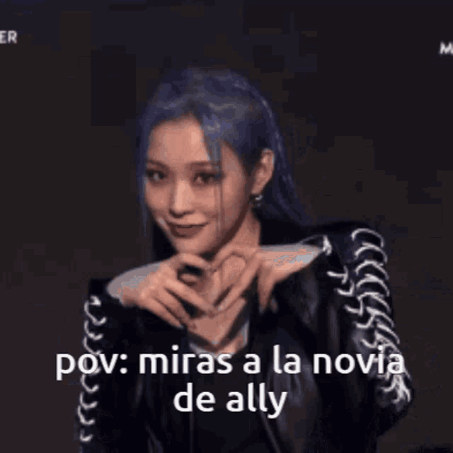 a woman with blue hair is making a heart shape with her hands and says pov miras a la novia de ally .