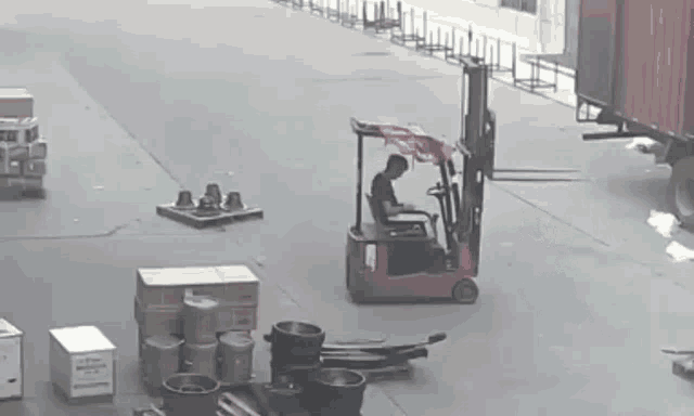 a man is driving a forklift in a warehouse .