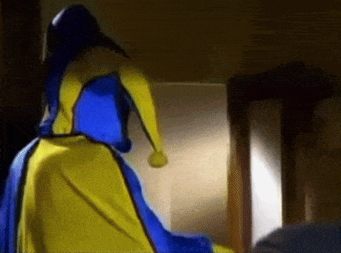 a woman in a blue and yellow dress is standing in front of a mirror in a room .