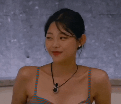 a woman wearing a striped bikini top and a necklace is smiling