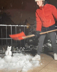 a woman in a red jacket is shoveling snow with an orange shovel