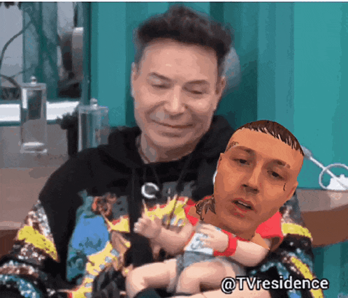 a man is holding a baby doll with a picture of a man on it