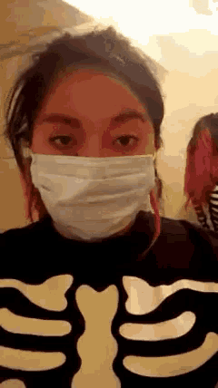 a girl wearing a face mask and a skeleton shirt