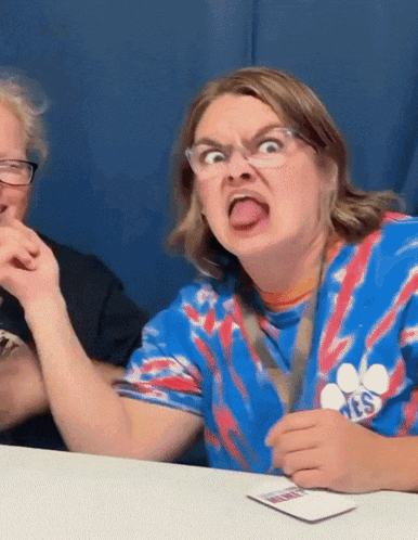a woman wearing a tie dye shirt with paws on it making a face