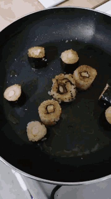 a frying pan filled with fried food including a few pieces of rice