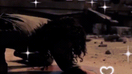 a woman is kneeling down on the floor with hearts surrounding her and sparkles .