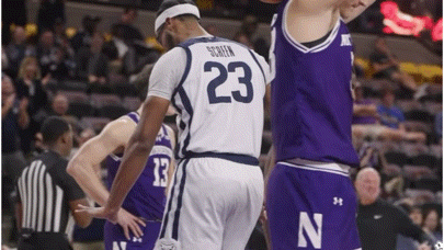 a basketball player with the number 23 on his jersey is standing next to another basketball player .