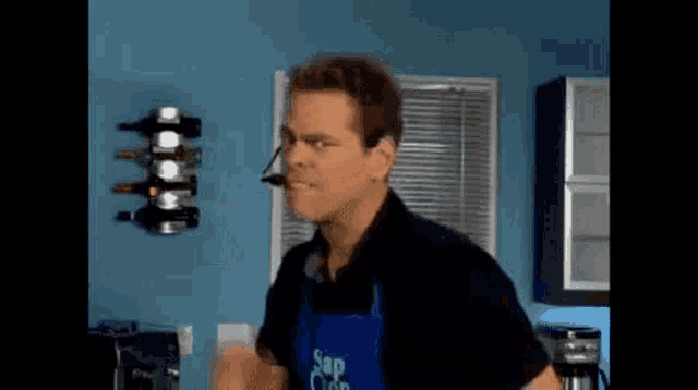 a man wearing a blue apron that says sap on it