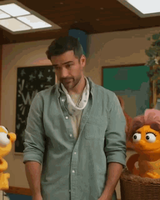 a man with a bandana around his neck is standing in front of stuffed animals and a blackboard that says welcome