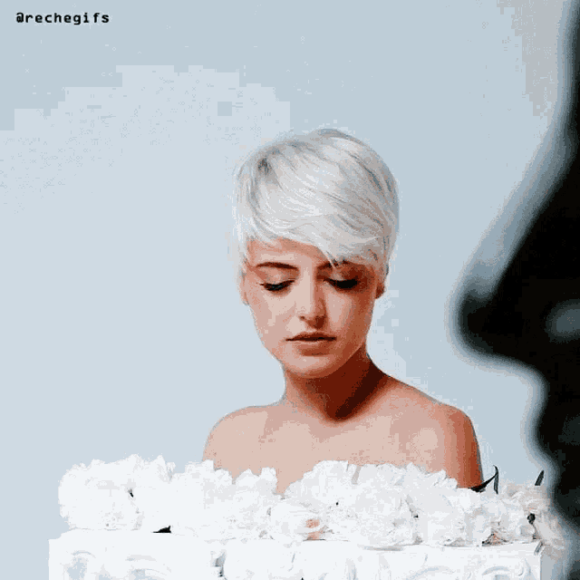 a woman with short white hair is surrounded by white flowers and the words arechegifs are above her