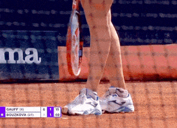 a woman holding a tennis racquet in front of a net that says gauff on it