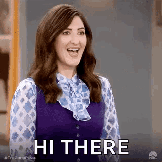 a woman wearing a purple vest and a blue and white shirt is smiling and says hi there .