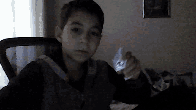a young boy holding a piece of paper that says ' a ' on it