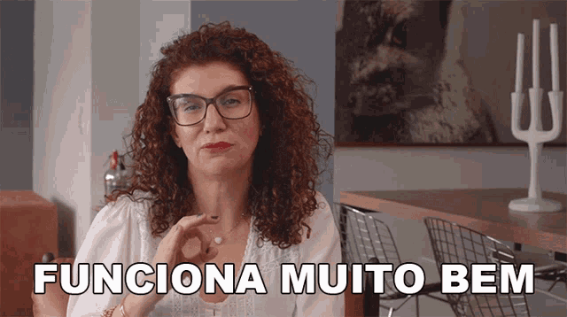 a woman wearing glasses and a white shirt says funciona muito bem