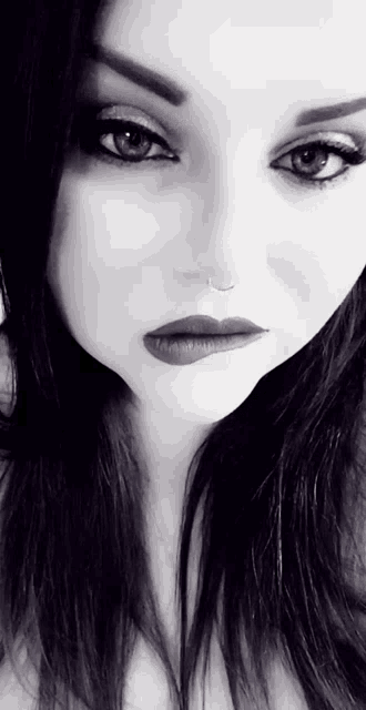 a close up of a woman 's face in a black and white photo