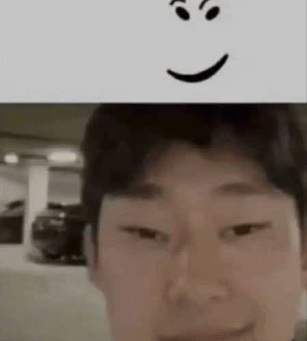 a close up of a man 's face with a smiley face next to it .