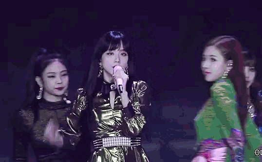a woman is singing into a microphone on a stage .