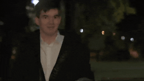 a blurry picture of a man in a suit and white shirt giving the middle finger .