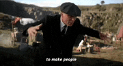 a man in a suit and hat is standing in a field and says to make people .