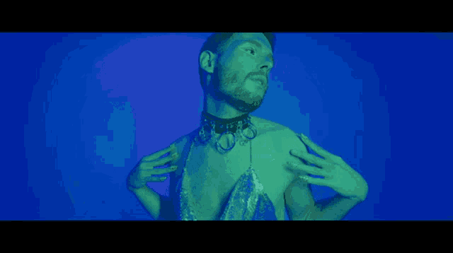 a man with a beard is wearing a choker necklace