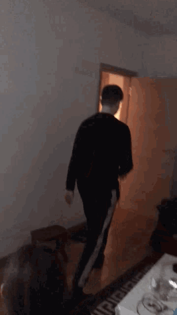a man in a black shirt is standing in a room