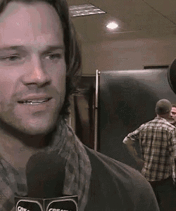 a man is talking into a microphone with the word cream on it