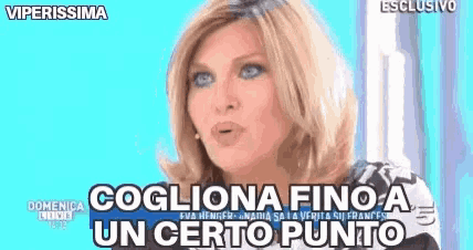 a woman with blonde hair and blue eyes is talking on a television show and says " cogliona fino a un certo punto "
