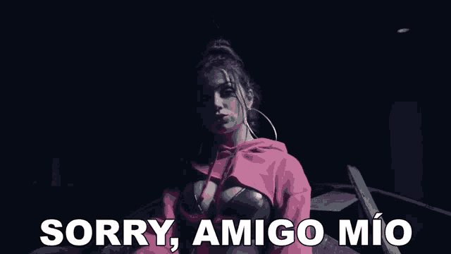 a woman in a pink hoodie with the words sorry amigo mio behind her