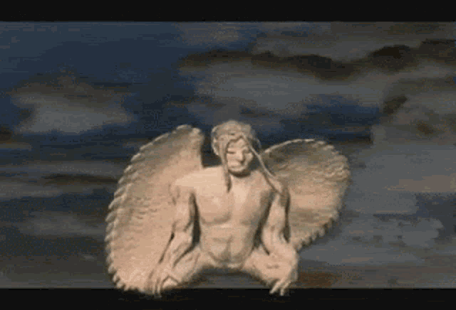 a statue of a man with wings is sitting on a cloudy sky .