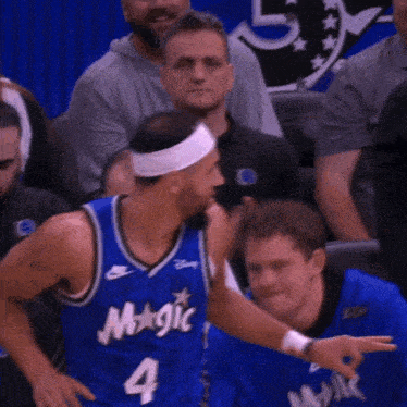 a basketball player wearing a blue jersey that says magic on it