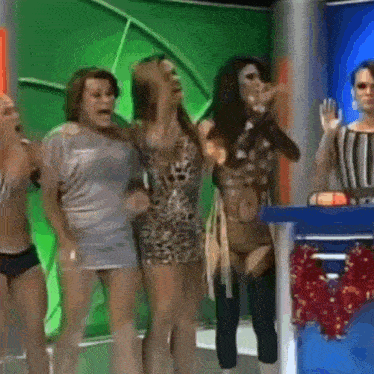 a group of women are standing next to each other in front of a green screen .
