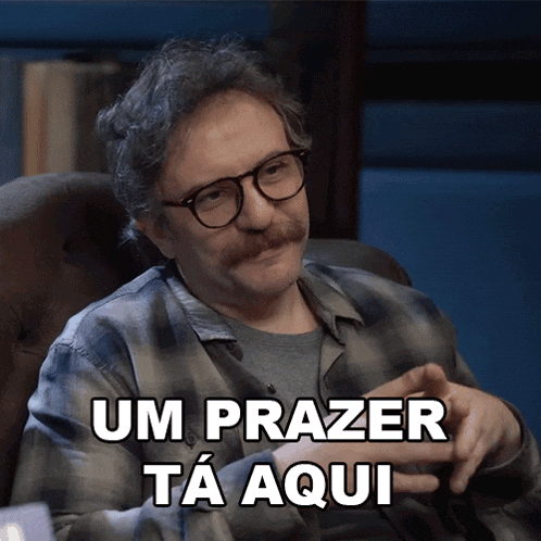 a man with glasses and a mustache is sitting in a chair with the words um prazer ta aqui above him