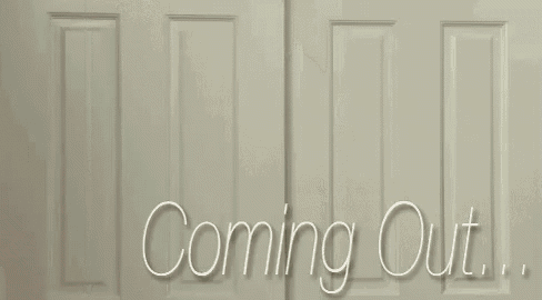 a man wearing glasses is peeking out of a door with the words coming out written on it .