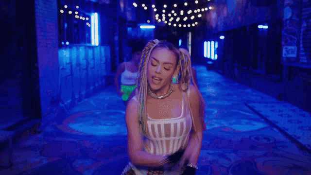 a group of women are dancing in a dark room with blue lights