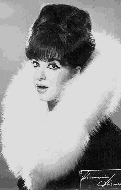 a black and white photo of a woman with a fur collar