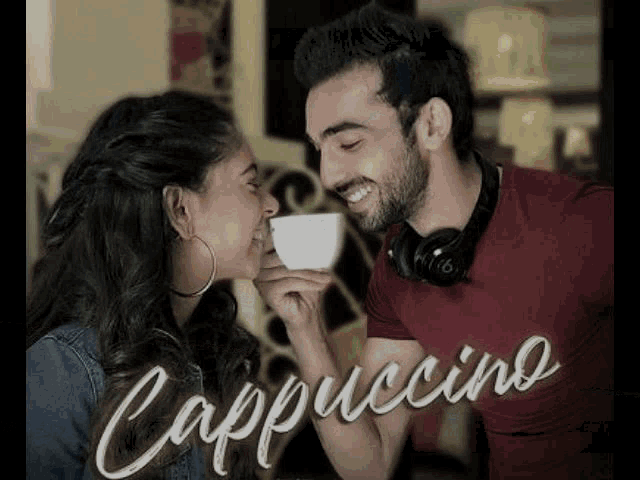 a man and a woman are kissing while holding a cup of cappuccino
