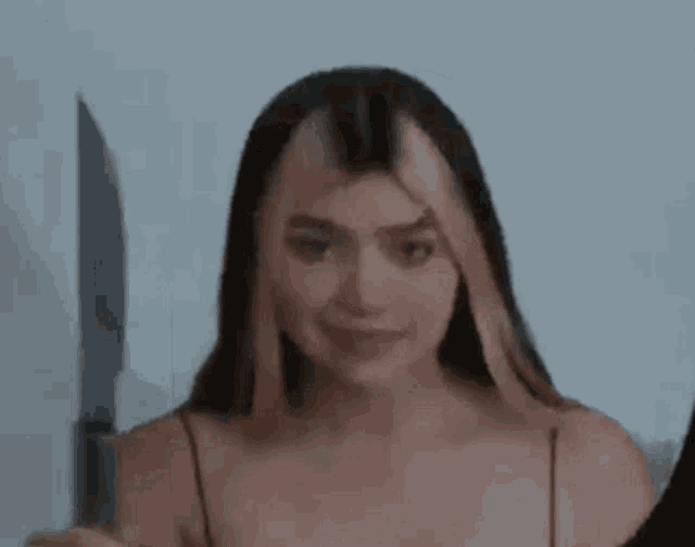 a woman is holding a knife in front of her face .