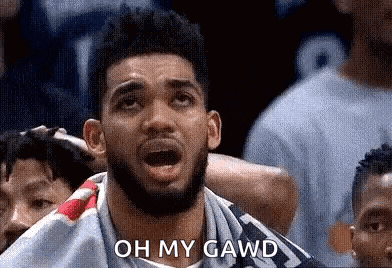 a man with a beard is sitting in a crowd watching a basketball game and saying `` oh my gawd '' .