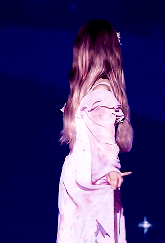 a woman in a pink dress holds a microphone