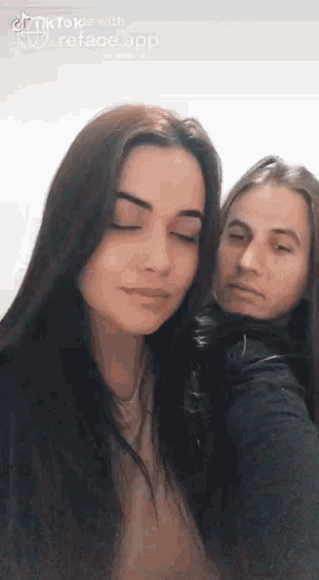 a man and a woman are posing for a picture with their eyes closed