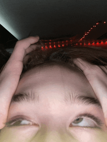 a person with their hands on their head looking up